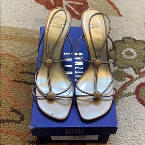 Stuart Weitzman “Trixietoo” gold sandals.